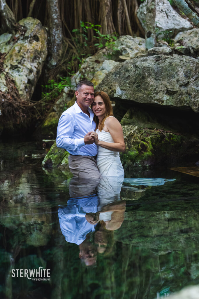 Surface water wedding photography inside a cenote surrounded by natural rock formations