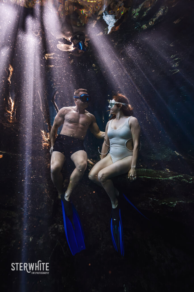 underwater couple looking each other in a romantic moment at the cenote
