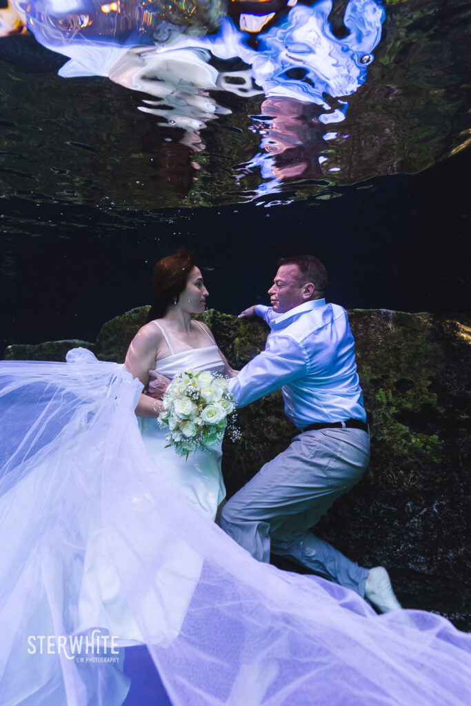 romantic underwater moment after the wedding day and during their trash the dress photosession