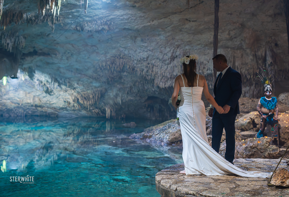 Couple in a intimate moment during a Mayan ceremony inside a cenote