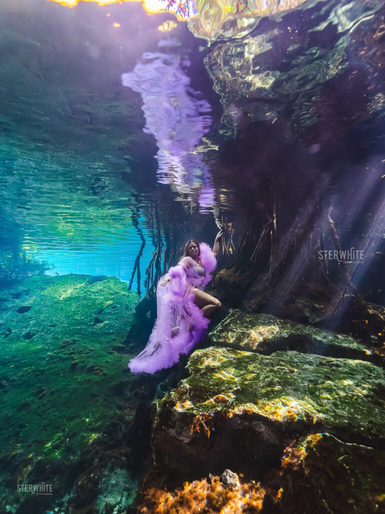 Underwater birthday portrait in a cenote with flowing dress